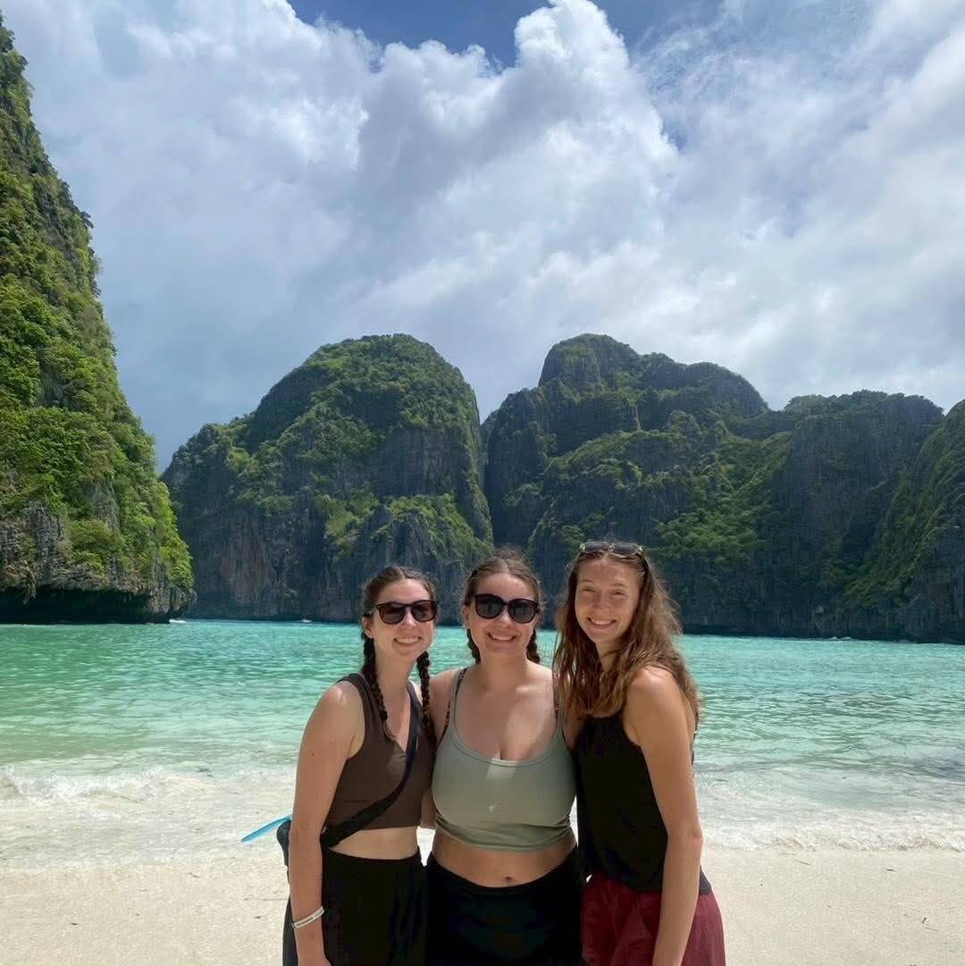 Three guests posing on the beach with Phang Nga Bay limestone cliffs behind