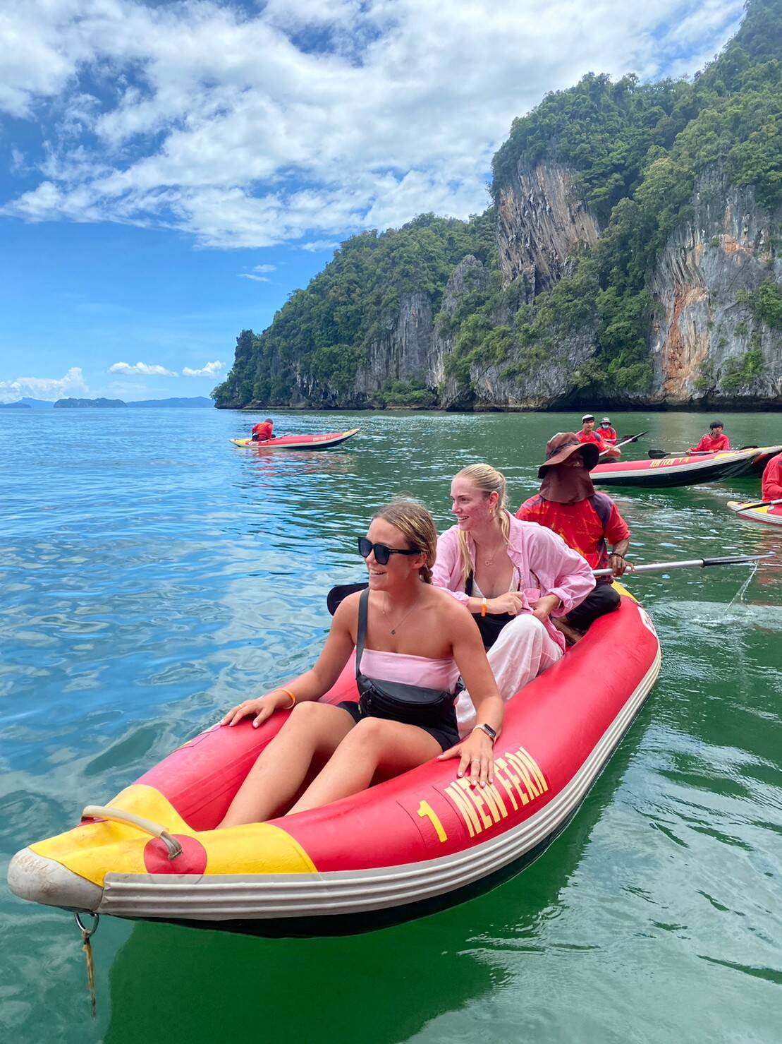 Guests riding a sea cave canoe past the karst cliffs of Phang Nga Bay