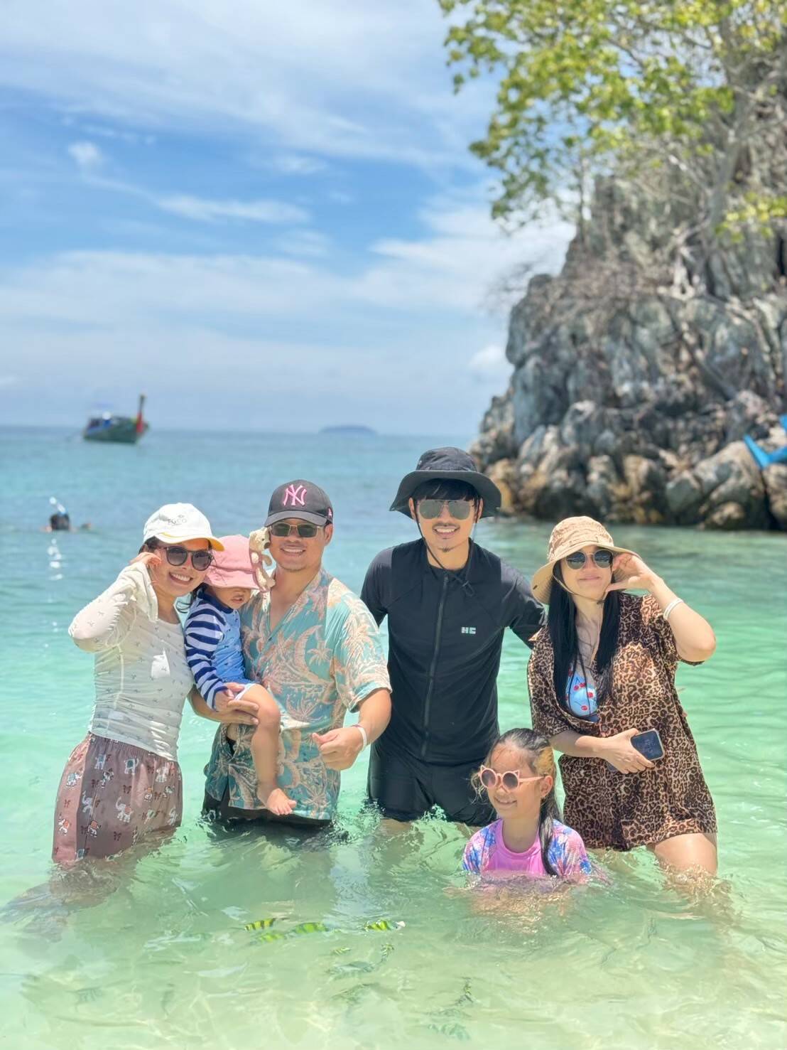 A family wading in the shallow water at Khai Island