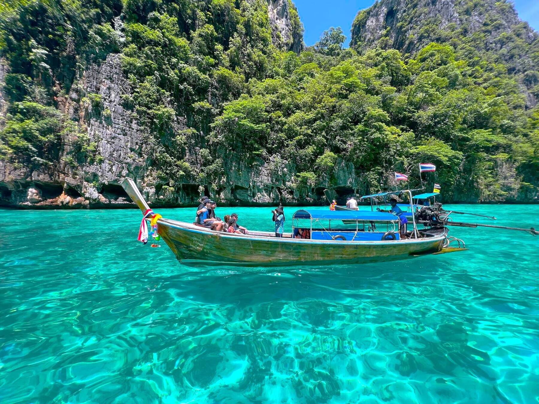 Longtail boats moored in the turquoise lagoon at Phi Phi