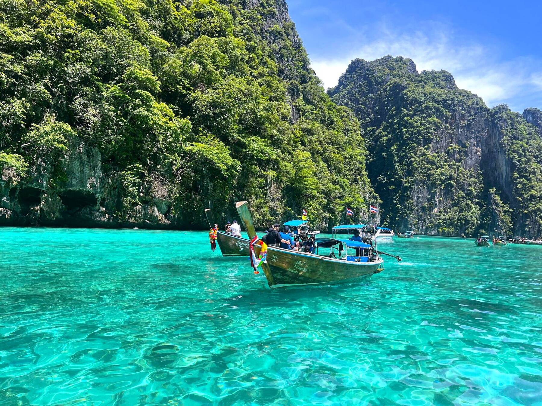 Two longtail boats anchored in Phi Phi's turquoise lagoon