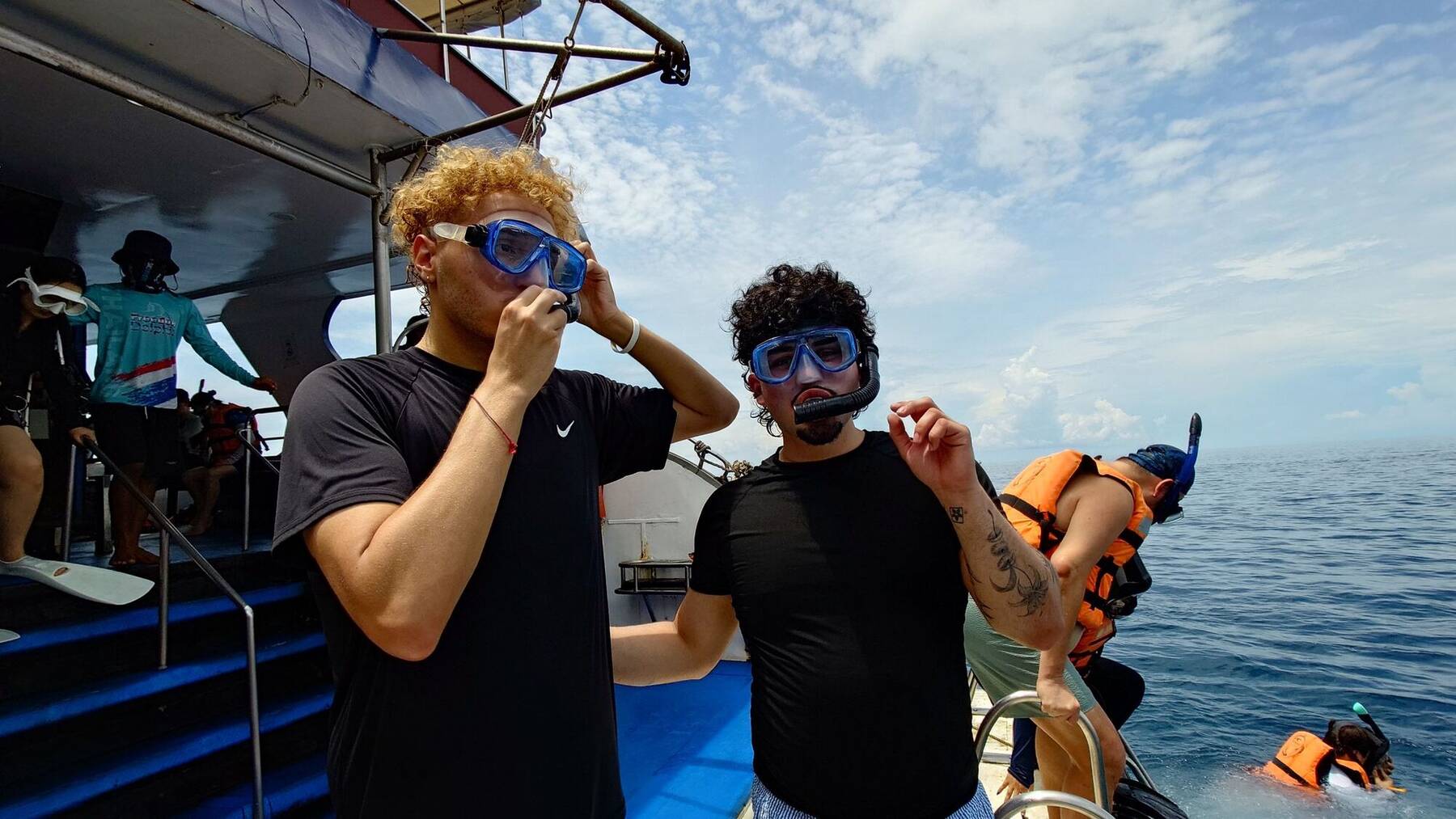 Guests putting on snorkeling masks on the boat