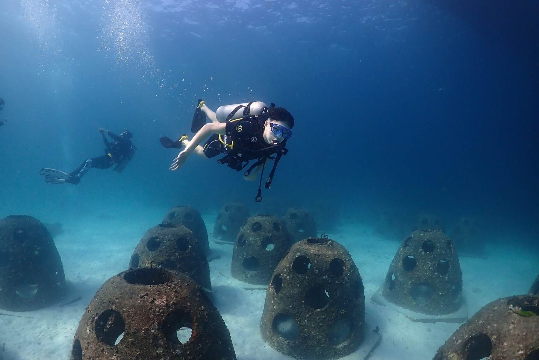 Divers exploring an artificial reef structure at Racha Island